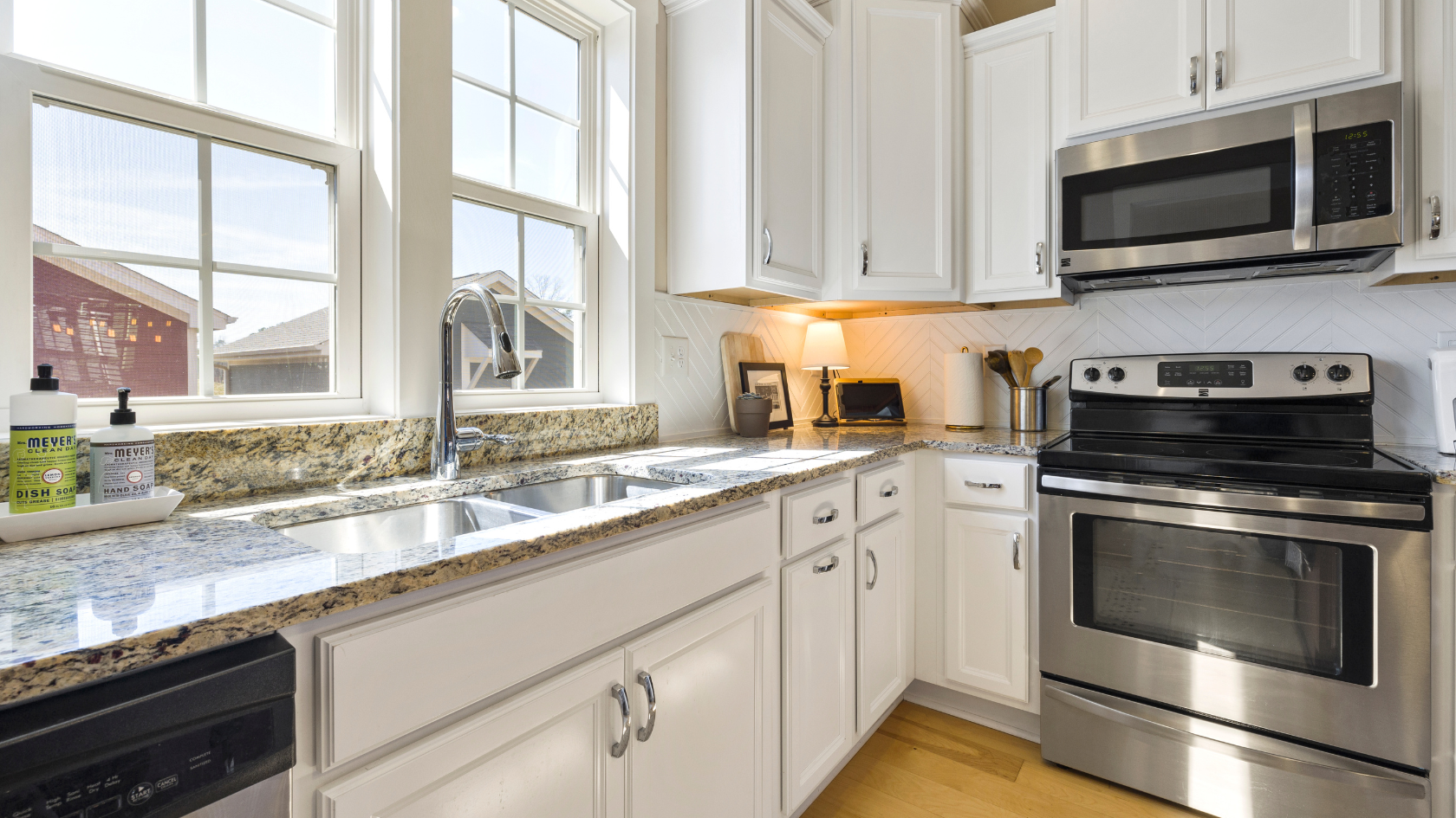 A kitchen with white cabinets and stainless steel appliances